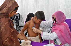 Lady Doctor examine a child in a medical camp during Health Week at THQ Hospital Chak no 90 SB