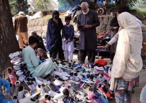 Vendors waiting for costumers on his secondhand shoes stall at roadside in the Federal Capital.