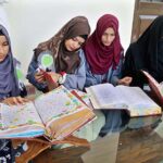 Students viewing the calligraphy work of Quranic verses during Exhibition of calligraphy at Government Collage University.