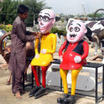 A vendor displaying statues to attract the customer at Eidgah road