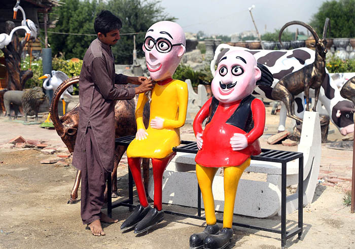 A vendor displaying statues to attract the customer at Eidgah road