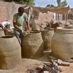 An artisan busy in preparing traditional clay oven (tandoor) at his workplace