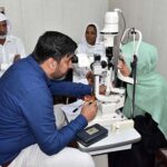 A doctor examining and eye patient during Sharifan Babi Free Medical Camp organizer Shade Trust