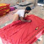 A worker busy in preparing quilt for upcoming winter season.