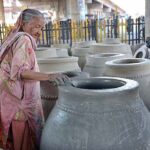 An elderly woman busy in preparing traditional oven “Tandoor” at her workplace.