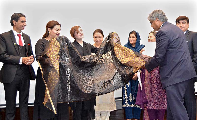 IAC Chancellor Muhammad Faisal Janjua presents a shawl to the Prime Minister's Special Assistant on Human Rights Ms. Mashaal Hussain Malik on the occasion of a seminar on women's empowerment at the Institute of Art and Culture