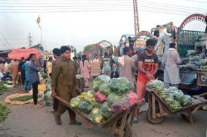 Labourers carrying vegetables on hand cart deliver to at Vegetable Market in the city. 