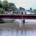People crossing Channel Mori Canal through Railway Bridge