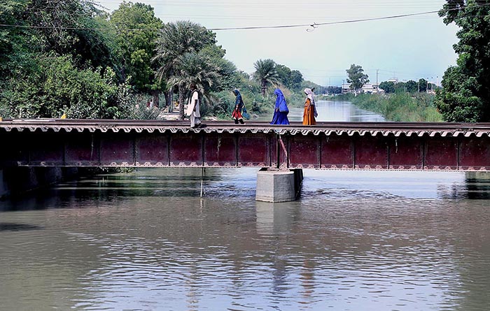 People crossing Channel Mori Canal through Railway Bridge
