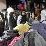 People purchasing clothes from a vendor at H9 Bazar in the Federal Capital