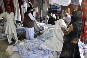 People purchasing clothes from a vendor at H9 Bazar in the Federal Capital