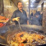 A vendor roasting chicken for customers at Hashtnagri area