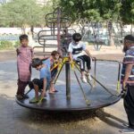 Children enjoying on marry-go-round in the premises of Frere Hall building