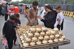Women and children are busy shopping for golden Golak (money boxes) following the traditional method of collecting money from a cart near Bibi Pak Daman