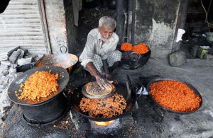 An elderly vendor preparing traditional sweet item at Waleed Mohallah.