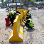 Labourers busy in paint the road divider at Egerton Road