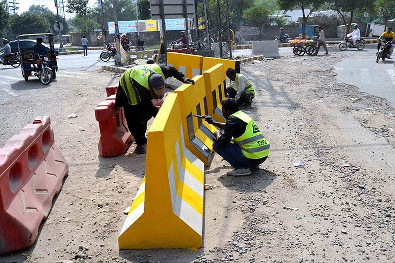 Labourers busy in paint the road divider at Egerton Road