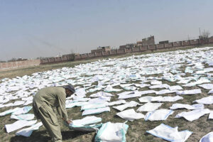 A worker drying washed plastic bags under the sun at his workplace