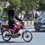 Woman riding motorcycle on the way towards her destination in the City