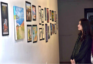Students of National College of Arts viewing the displayed artwork during an exhibition in the college
