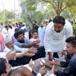 Poultry workers distributing eggs during a walk on the eve of World Egg Day organized by Shabbir Poultry Services