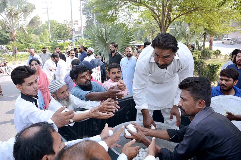 Poultry workers distributing eggs during a walk on the eve of World Egg Day organized by Shabbir Poultry Services