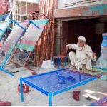 An artisan knitting traditional bed (Charpai) to earn livelihood at his workplace