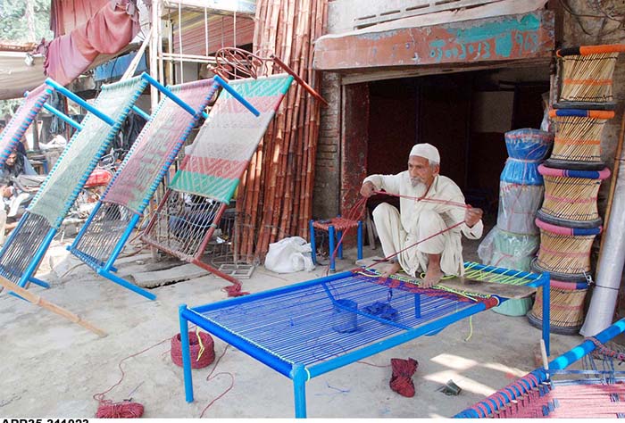 An artisan knitting traditional bed (Charpai) to earn livelihood at his workplace