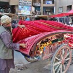 Worker busy to shift blankets in his shops at Meezan Chowk.