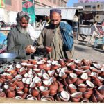 People buying coconuts from a vender at Meezan Chowk which demands increased in winter season