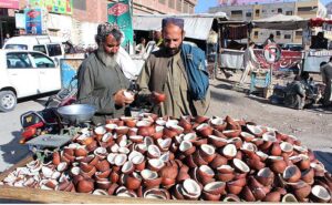 People buying coconuts from a vender at Meezan Chowk which demands increased in winter season