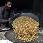 A worker busy in roasting grams for customers at his workplace