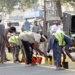 Workers busy in painting the footpath at Mall Road