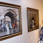 Female Visitor keenly viewing painting during the painting exhibition “Lahore Lahore hai” by Zahid Ashraf at Ejaz Art Gallery