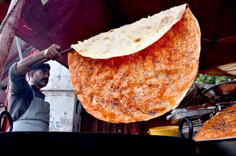 A vendor preparing the traditional food item (Katlama) to attract the customers on the roadside setup at Shadman in the Provincial Capita