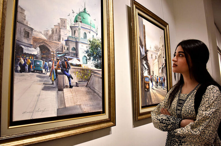 Female Visitor keenly viewing painting during the painting exhibition