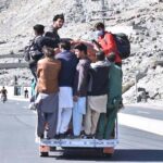 People hanging on passenger van in risky way may cause any mishap, needs the attention of concerned authorities.