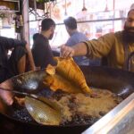A vendor frying fishes for customers at Qissa Khawani Bazaar