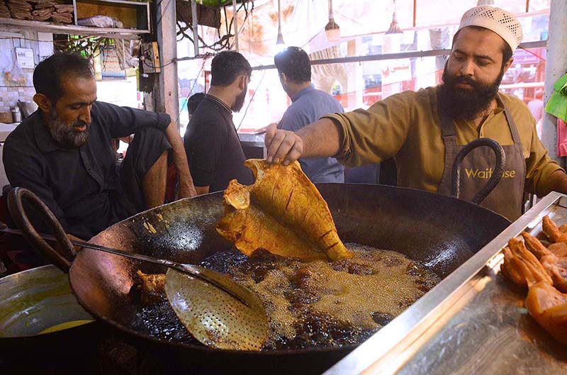 A vendor frying fishes for customers at Qissa Khawani Bazaar