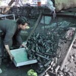 A vendor sorting coal for selling at his setup as demand increased during winter season