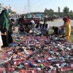 People purchasing used items from a roadside vendor at Khanna Pull