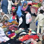 People busy in selecting second hand clothes from a vendor at Raja Bazaar