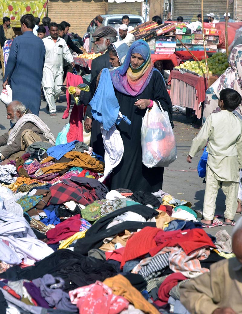 People busy in selecting second hand clothes from a vendor at Raja Bazaar