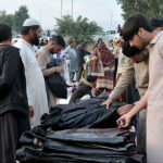 Customers are busy in selecting and purchasing second hand imported warm clothes from roadside vendor