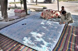 Worker busy arranging quilts at his shop for upcoming winter season at their workplace as the demand of warm goods increased after the temperature dropping rapidly in the city