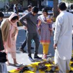 People purchasing old shoes from a roadside vendor at Abpara market in the Federal Capital