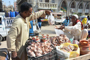 A person buying claymade lamps from vendor during Dewali festival