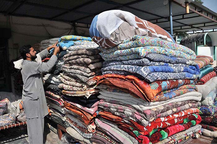 Worker busy arranging quilts at his shop for upcoming winter season at their workplace as the demand of warm goods increased after the temperature dropping rapidly in the city