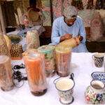 A craftsman making design on wooden lamp at his workplace