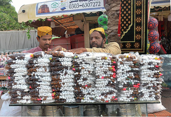 Shopkeeper displaying and selling sweet items at his shop